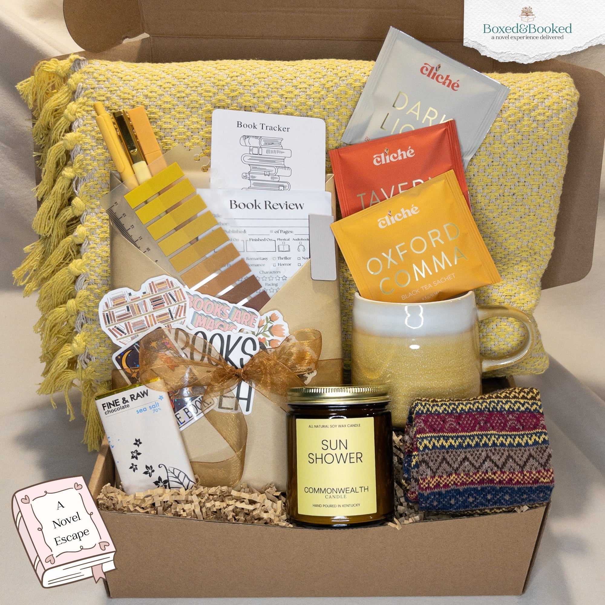 Gift box with a mug, candle, and other items on a yellow blanket